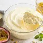 mousse cremosa de chocolate blanco de maracuyá en un bol de cristal, con una cucharada levantada
